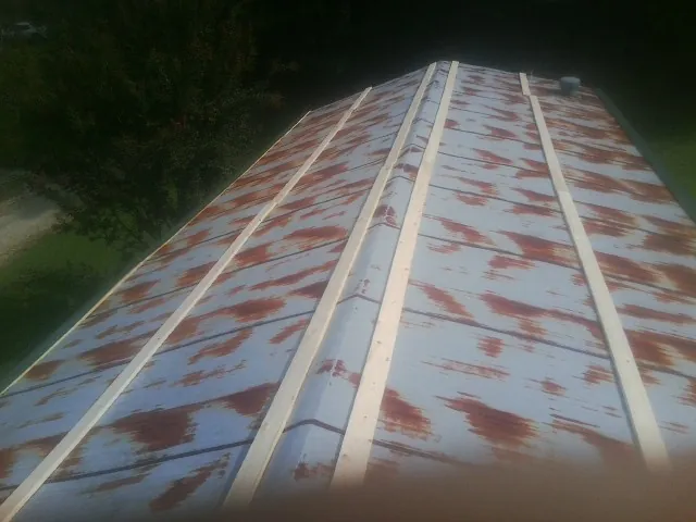 Rusted metal roof panels with new wood purlins before replacement — Storm Damage Roof Repair in Turbeville by Roofing Brothers