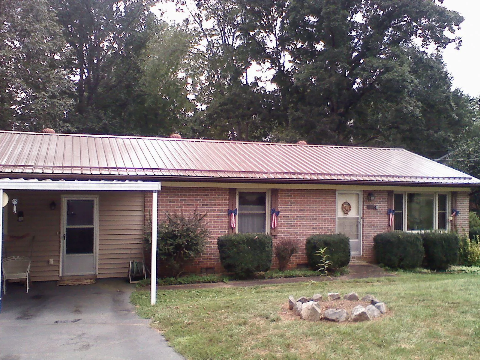 Bronze metal roof and carport on a brick ranch home — Roof Repair work by our crew in Turbeville